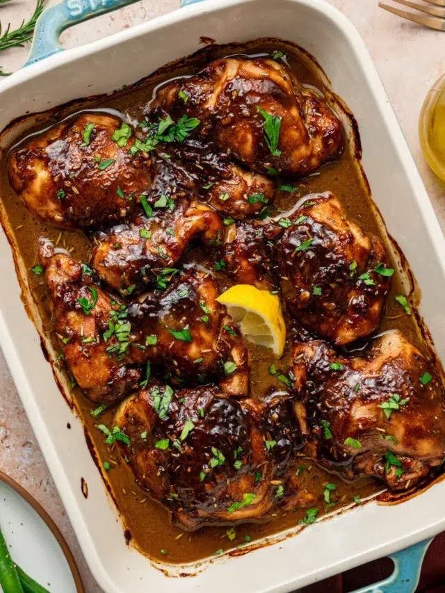 Balsamic Dijon mustard chicken thighs in a baking dish surrounded by ingredients.