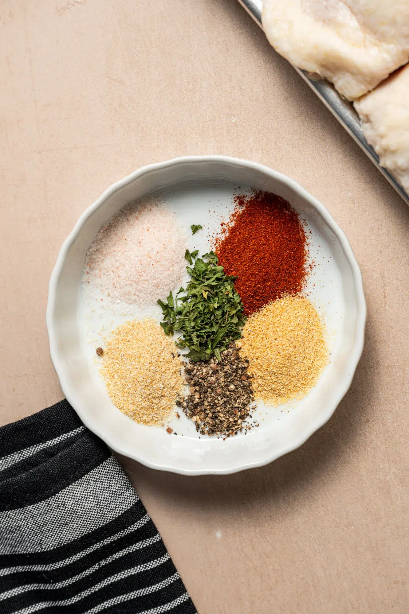 Spice portions separated on a small shallow white dish.