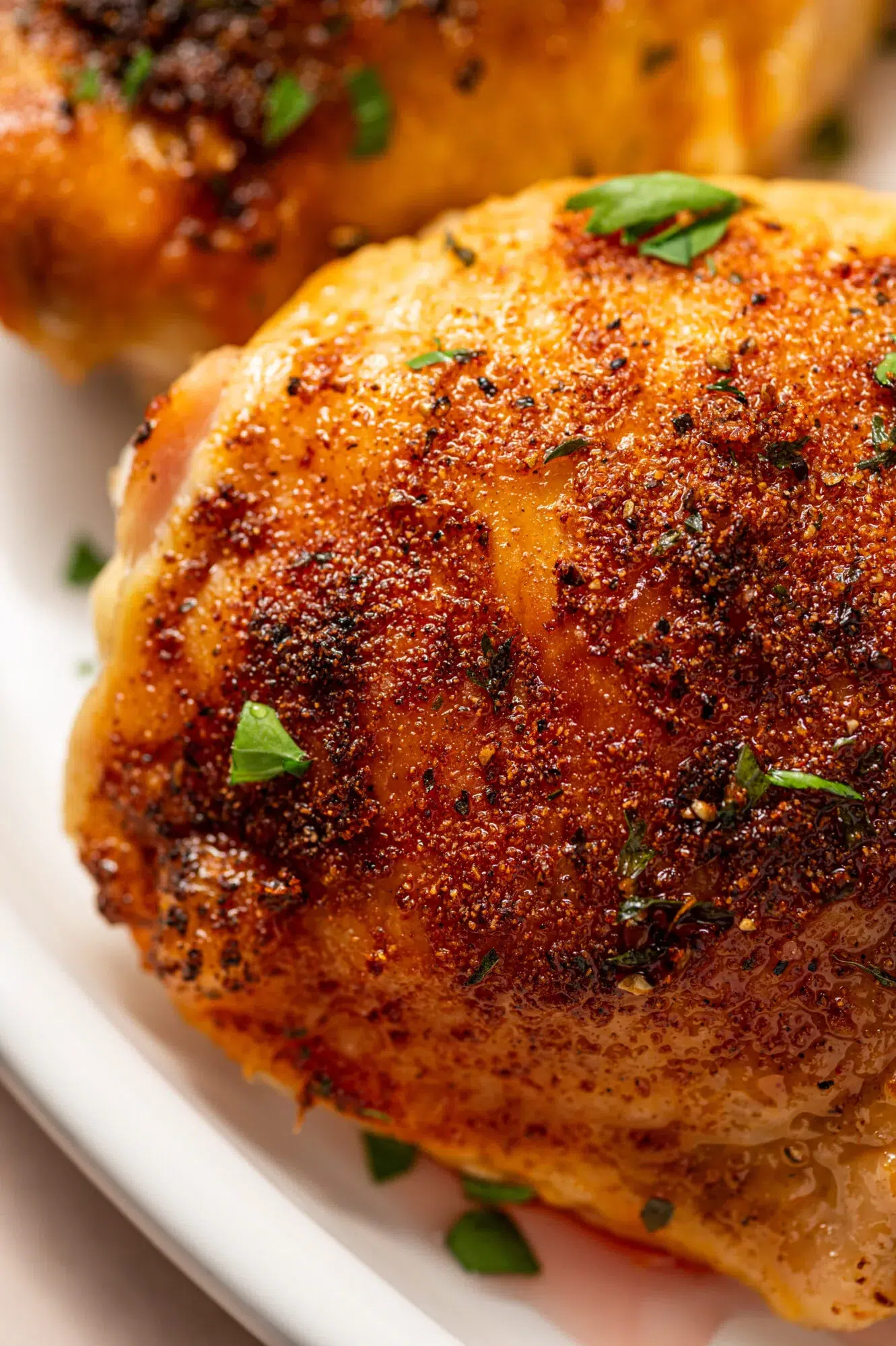 Close up of perfectly roasted chicken thighs garnished with parsley.