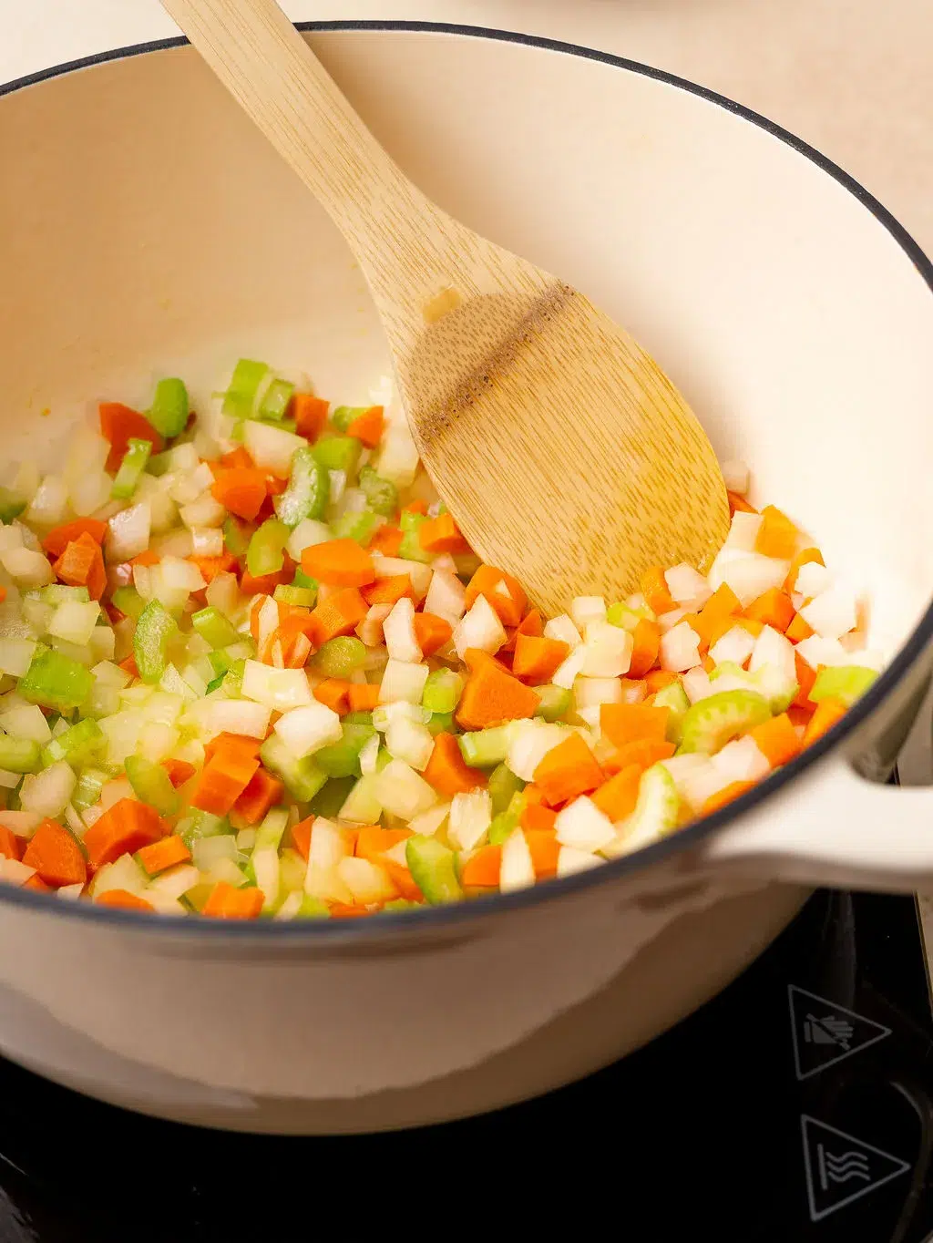 Diced carrots, celery, and onion sauteeing in a Dutch oven.