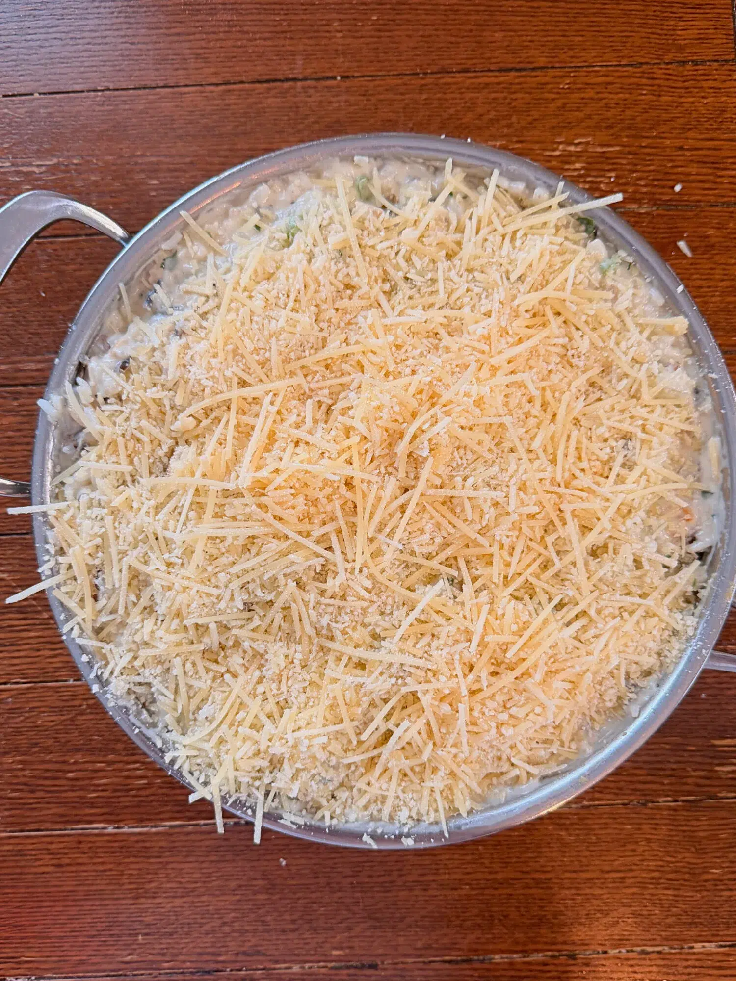 Shredded parmesan cheese topping layered over a chicken wild rice bake.