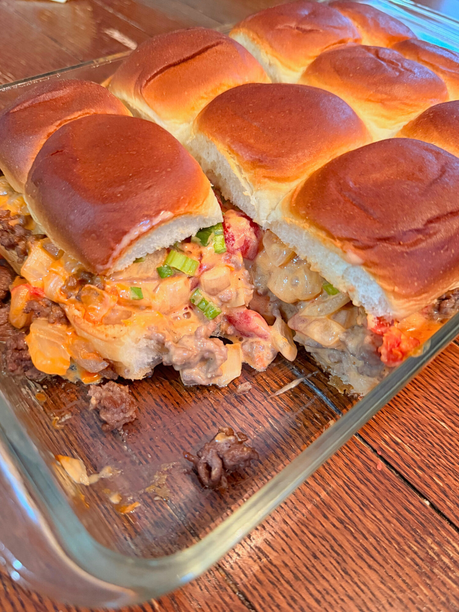 Stuffed ground beef queso sliders in a baking dish.
