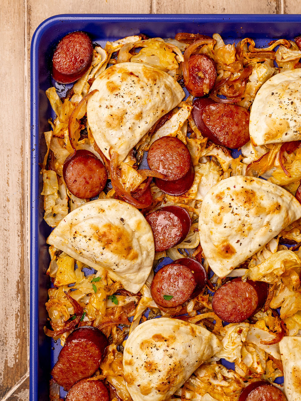 Pierogi and kielbasa on a sheet pan right out of the oven.