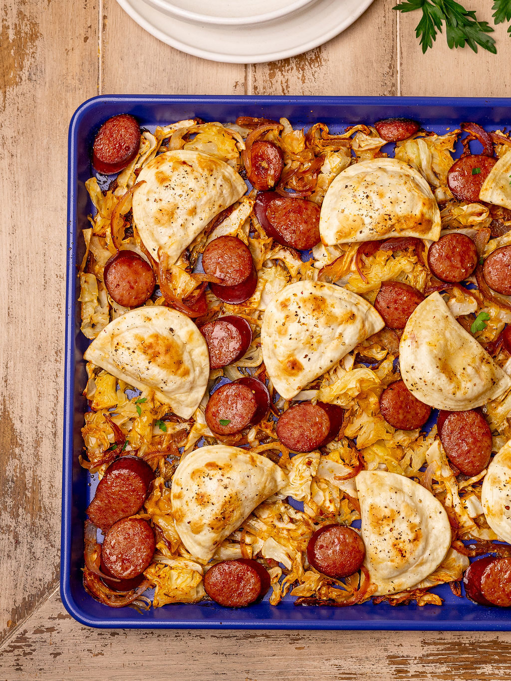 Pierogi and kielbasa on a sheet pan ready to eat.