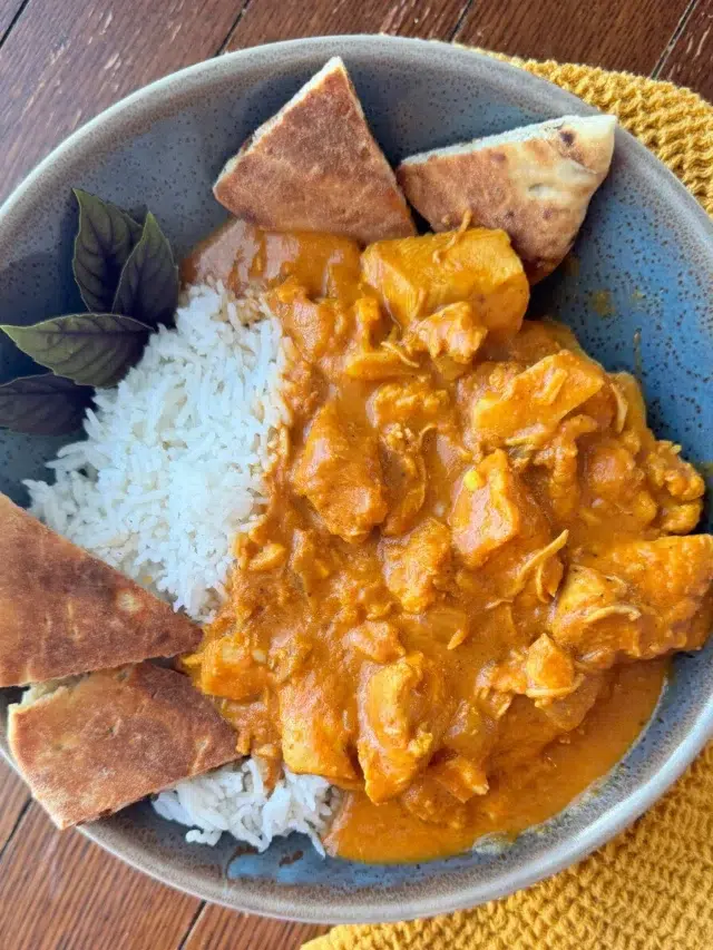 A serving of slow cooker butter chicken with naan.