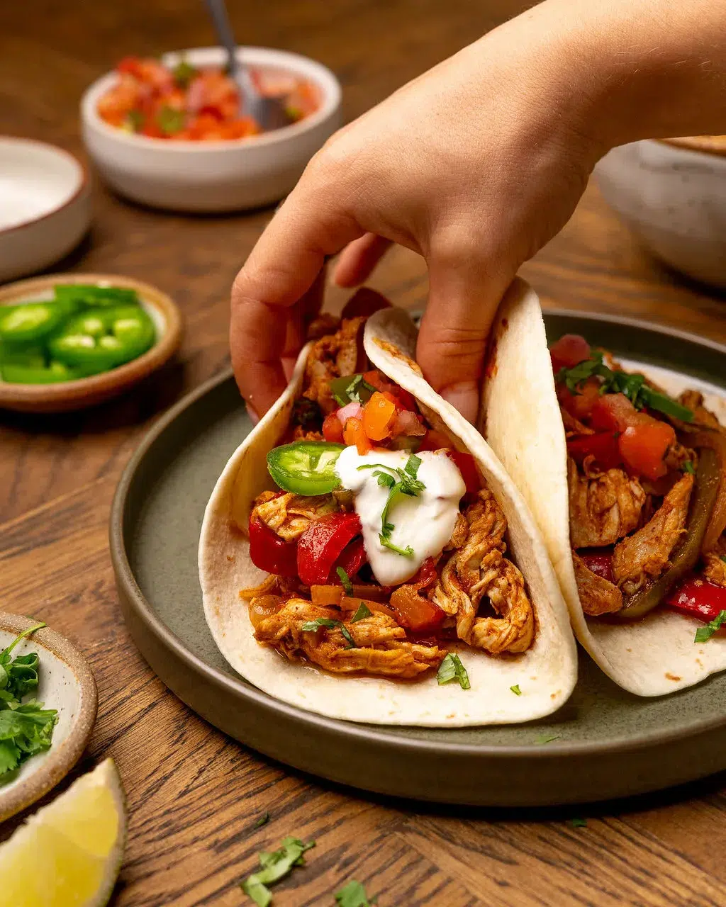 A hand grabbing slow cooker fajitas.