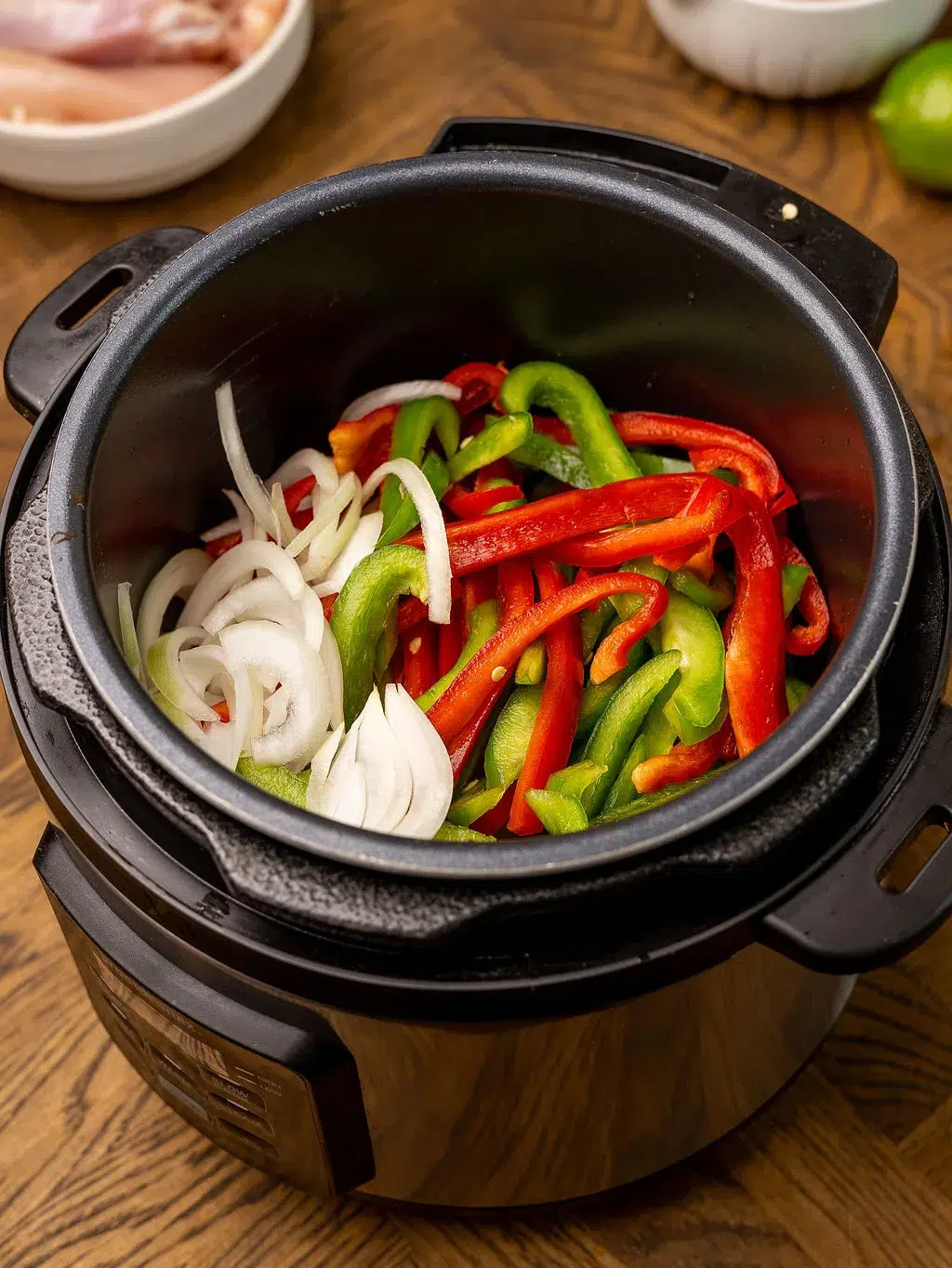 Sliced onion and bell pepper in a slow cooker.