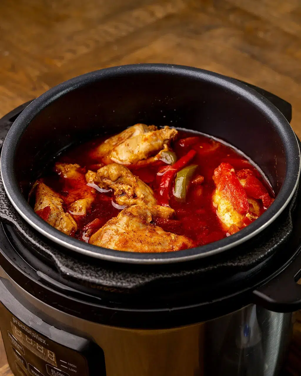 Cooked chicken in a slow cooker covered in sauce.