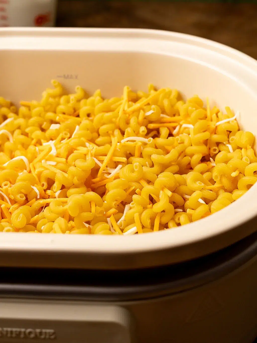 Noodles and cheese in a slow cooker.