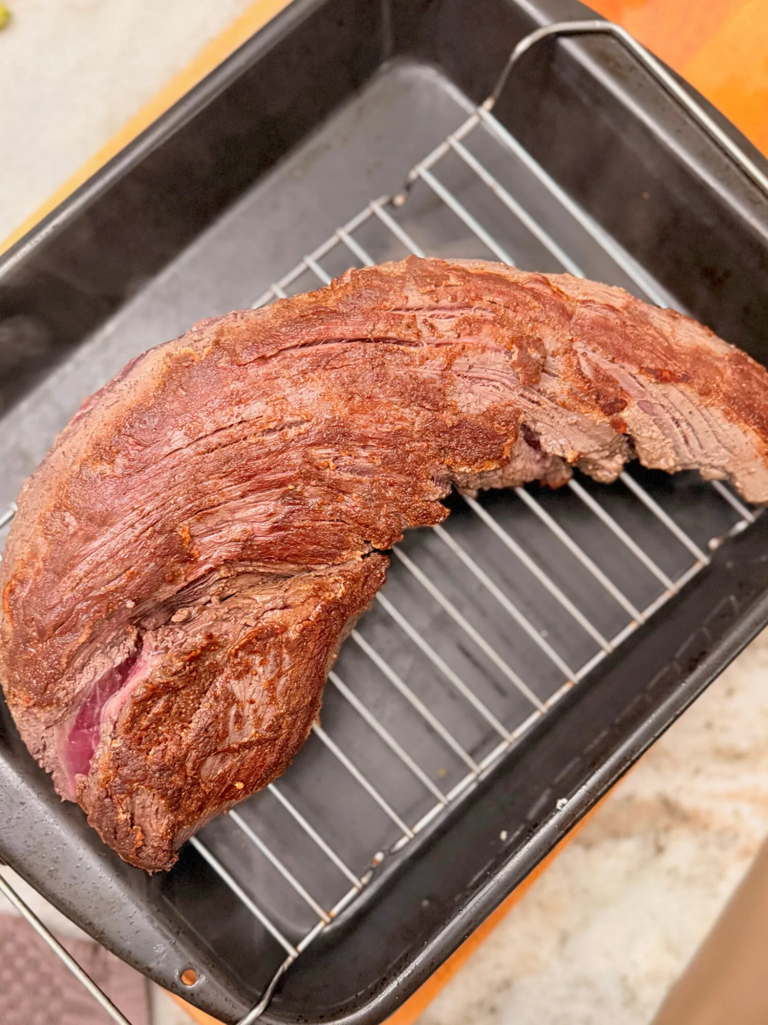 Seared beef tenderloin on a baking rack ready to go in the oven.