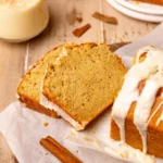 Two eggnog bread slices next to the loaf.