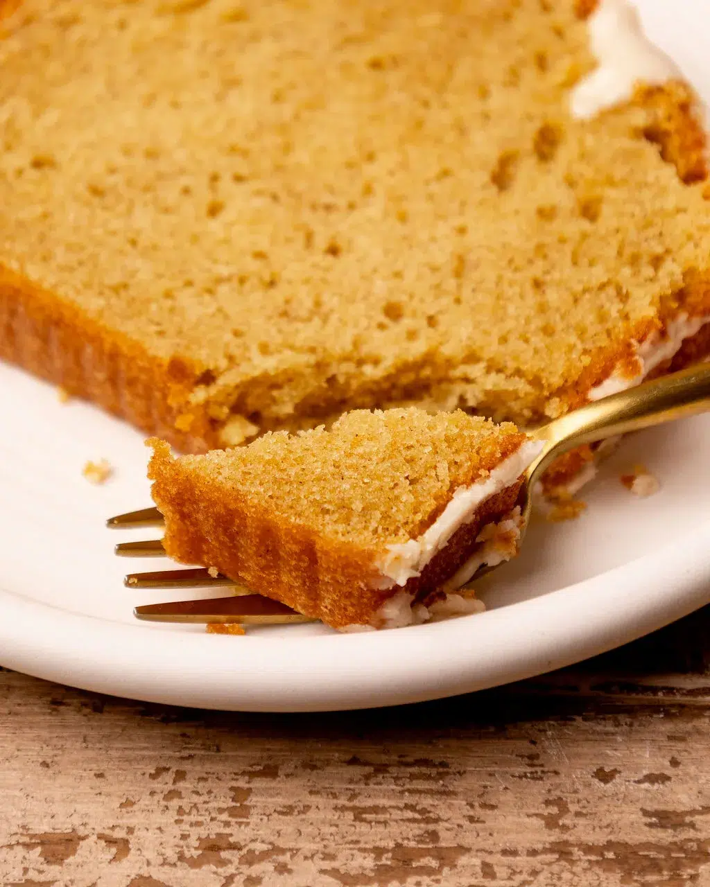 A fork with a corner piece of a slice of eggnog bread.