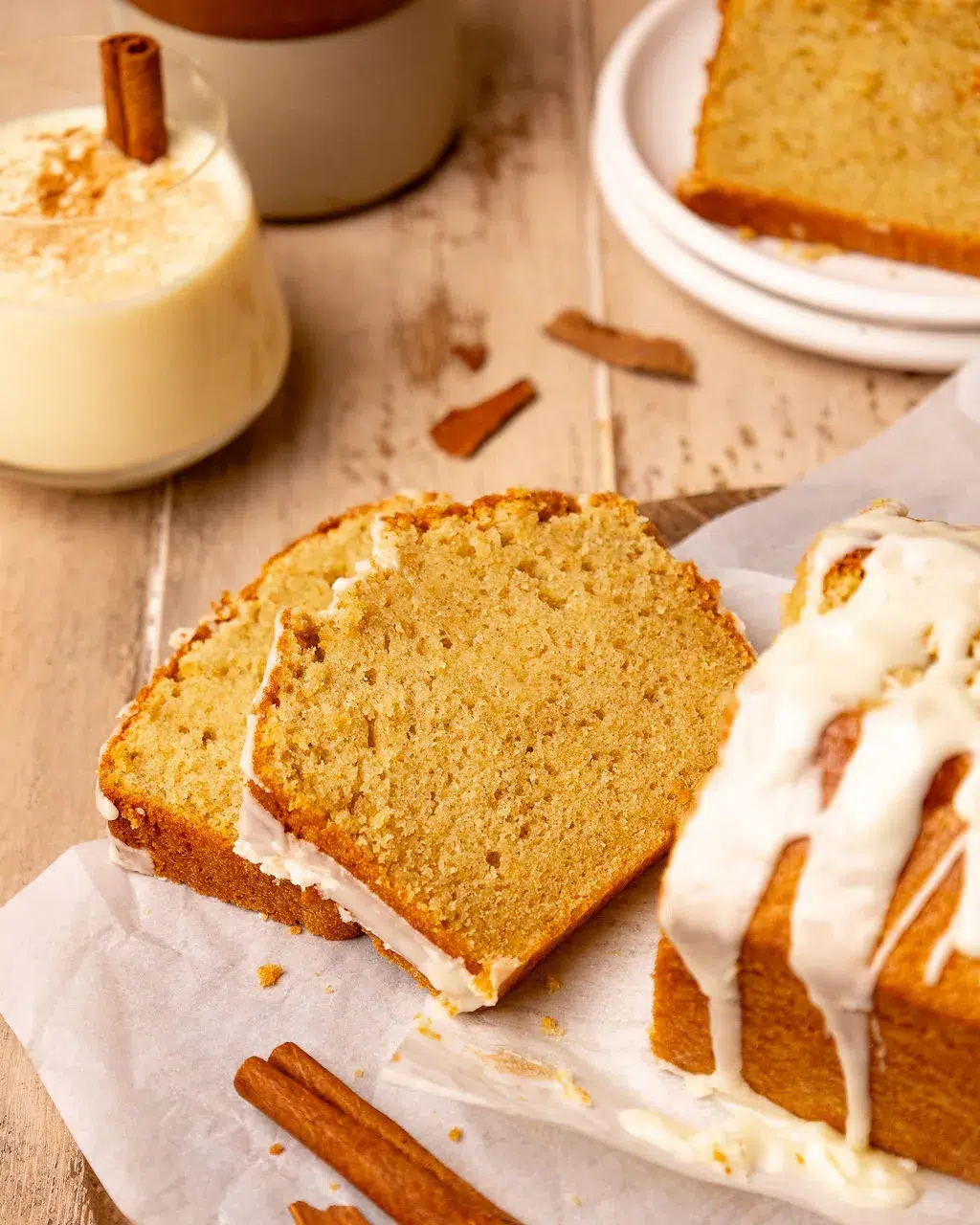 Two eggnog bread slices next to the loaf.