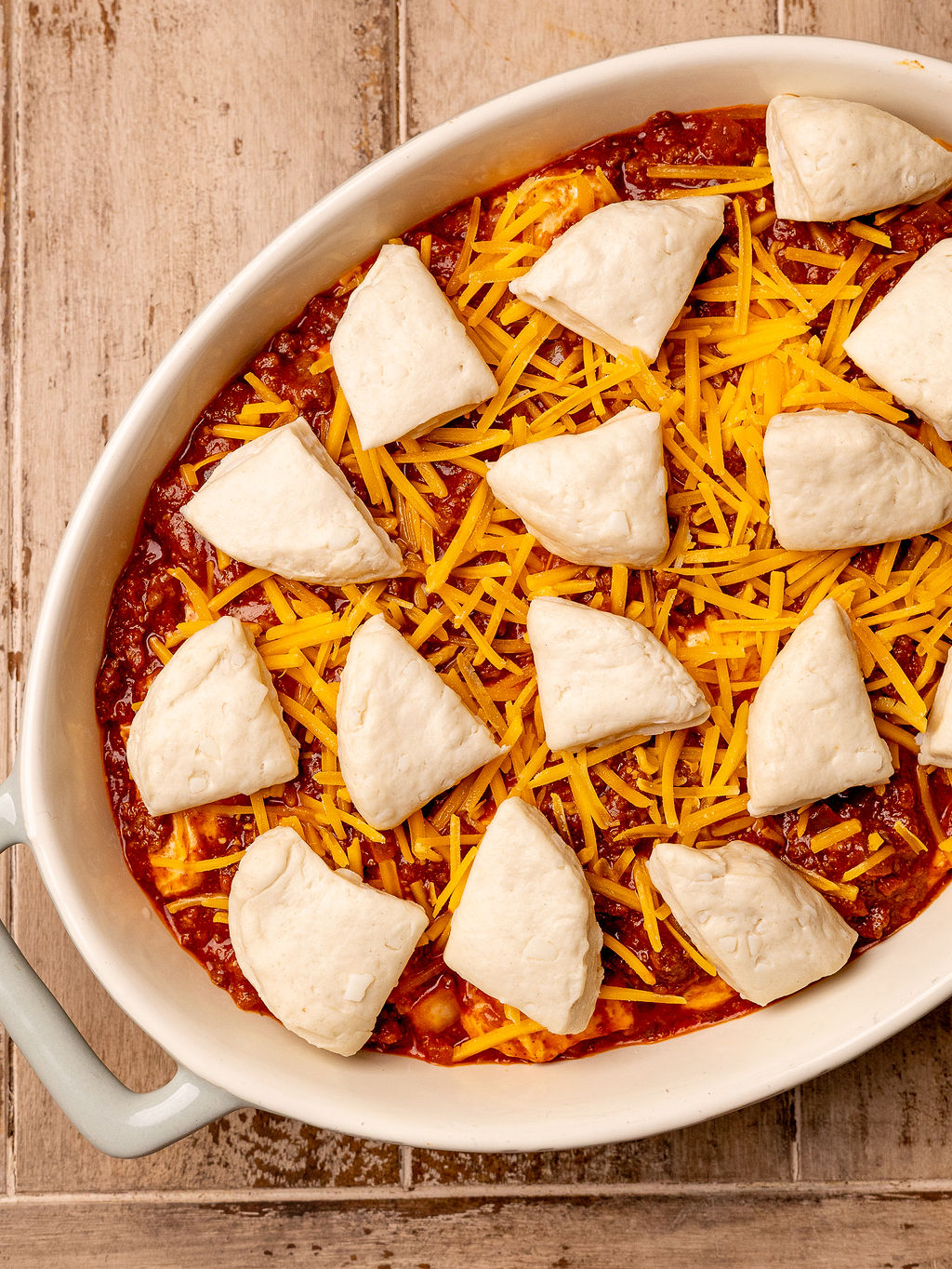 Biscuit dough over a casserole of sloppy joes.