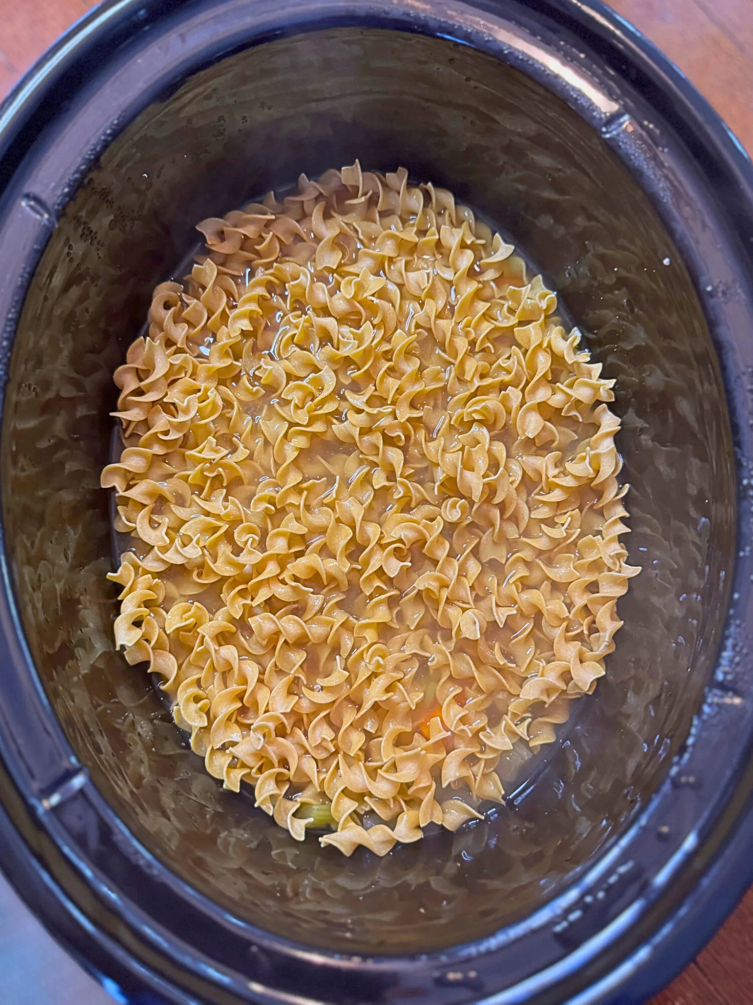 Pasta noodles in a slow cooker ready to cook.
