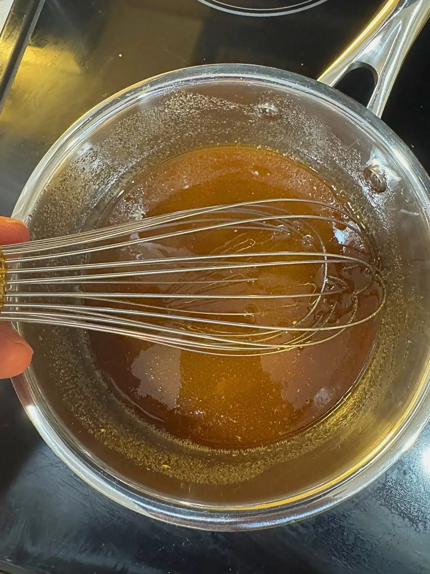 Honey glaze for slow cooker ham bubbling over the stove.