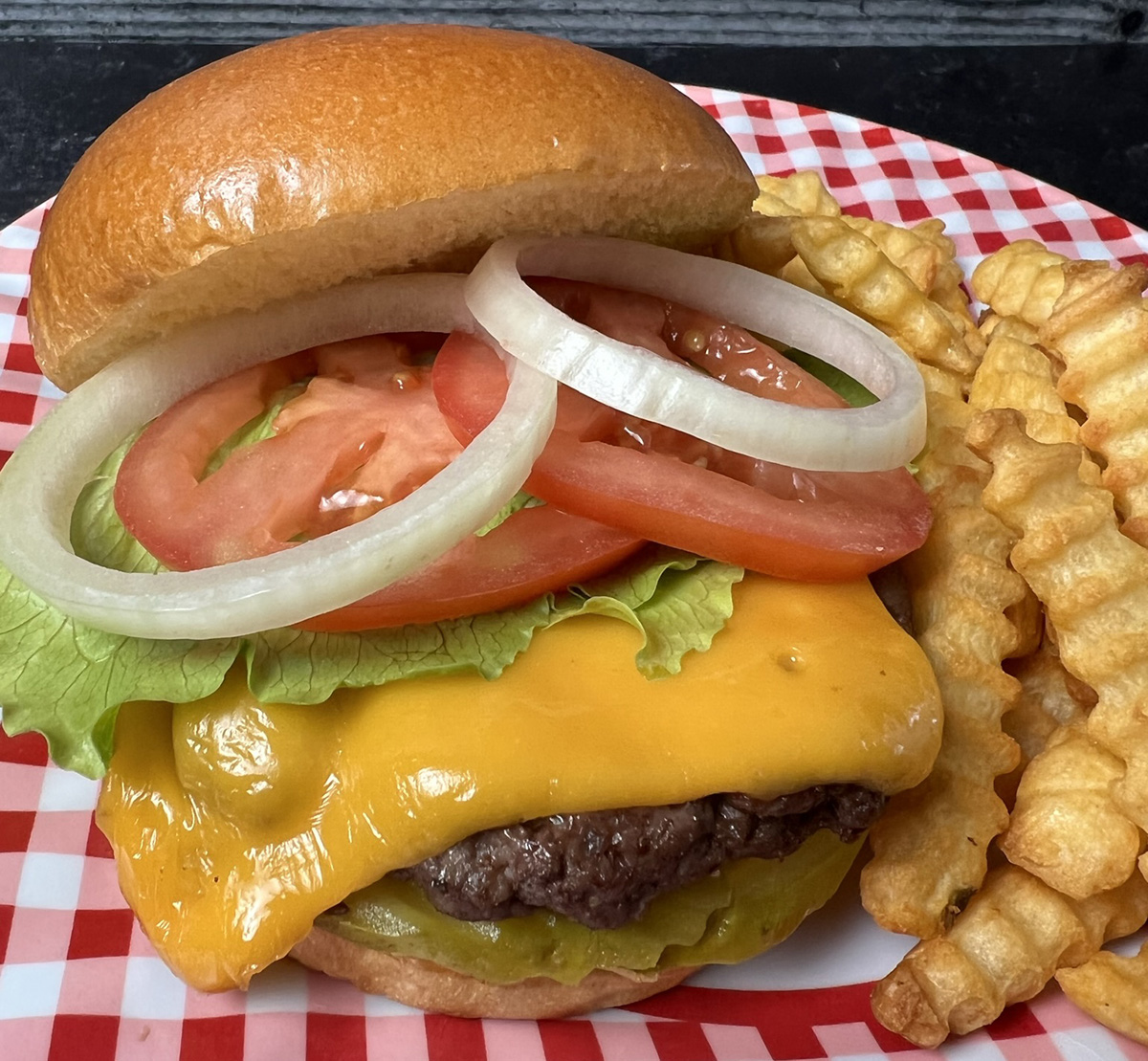 Best Damn Air Fryer Burgers served on a plate with toppings and fries on the side.