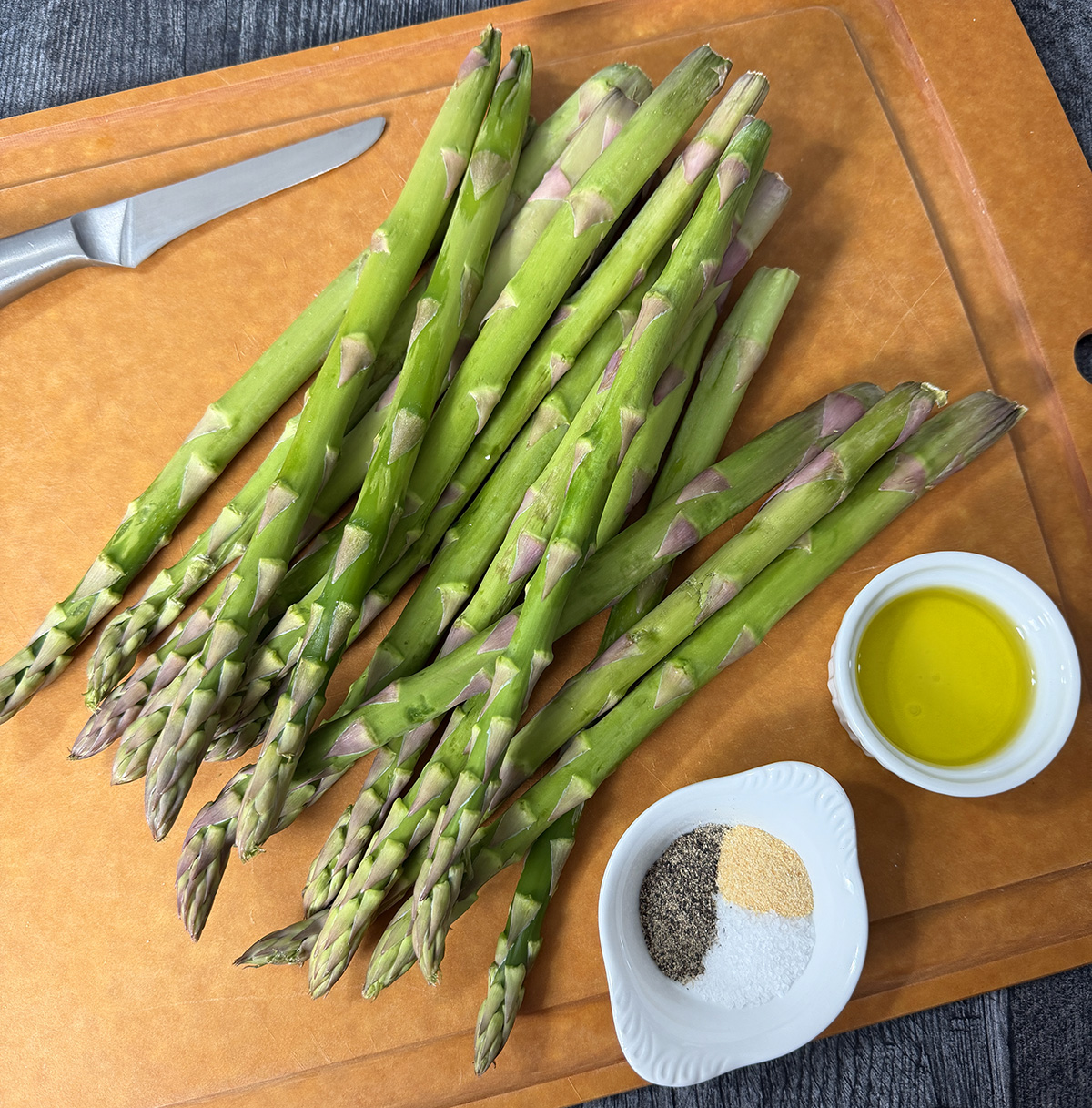 Preparing the asparagus to be roasted in the oven.