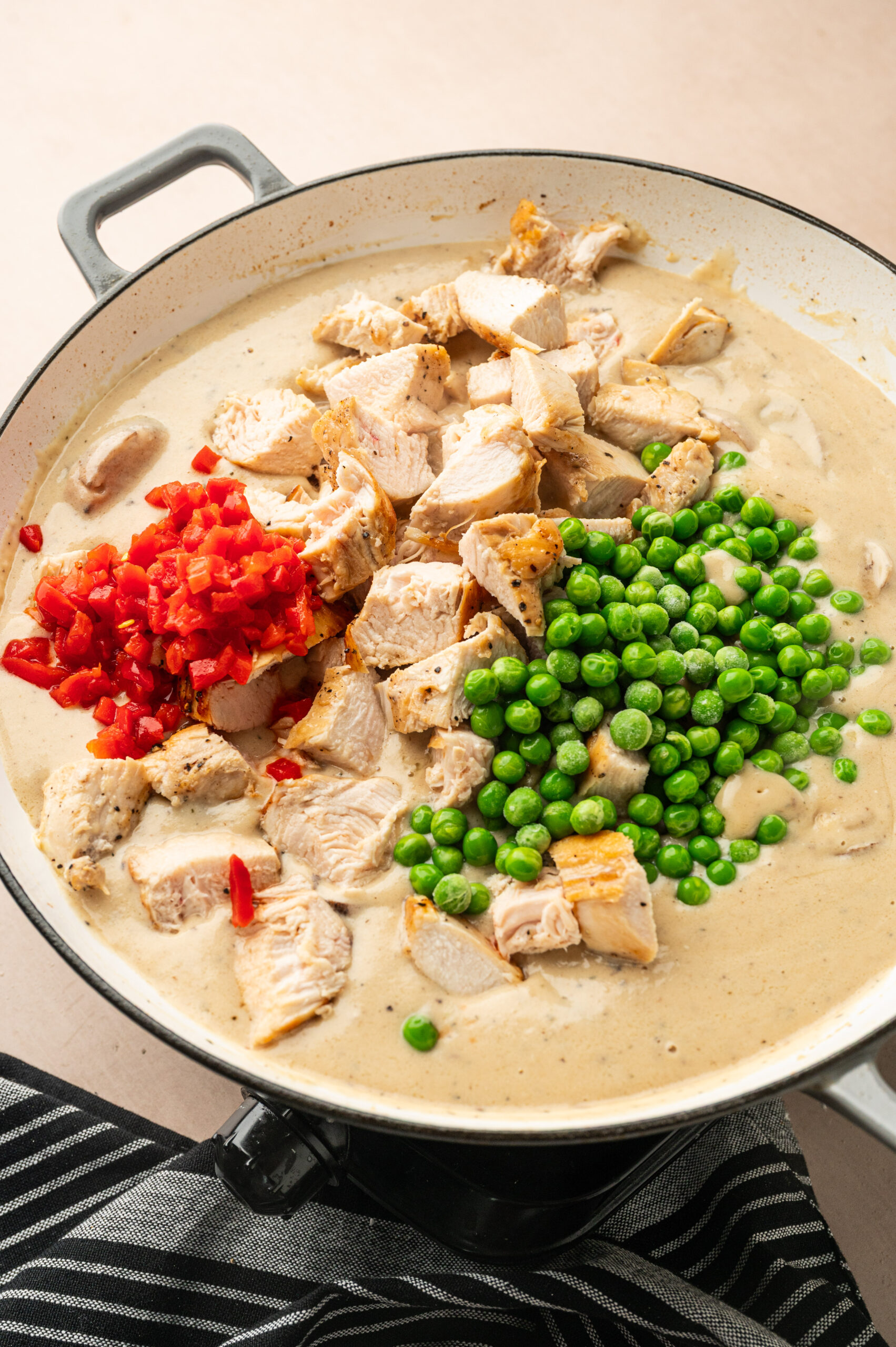 Peas, pimentos, and diced chicken in a creamy sauce before getting mixed.
