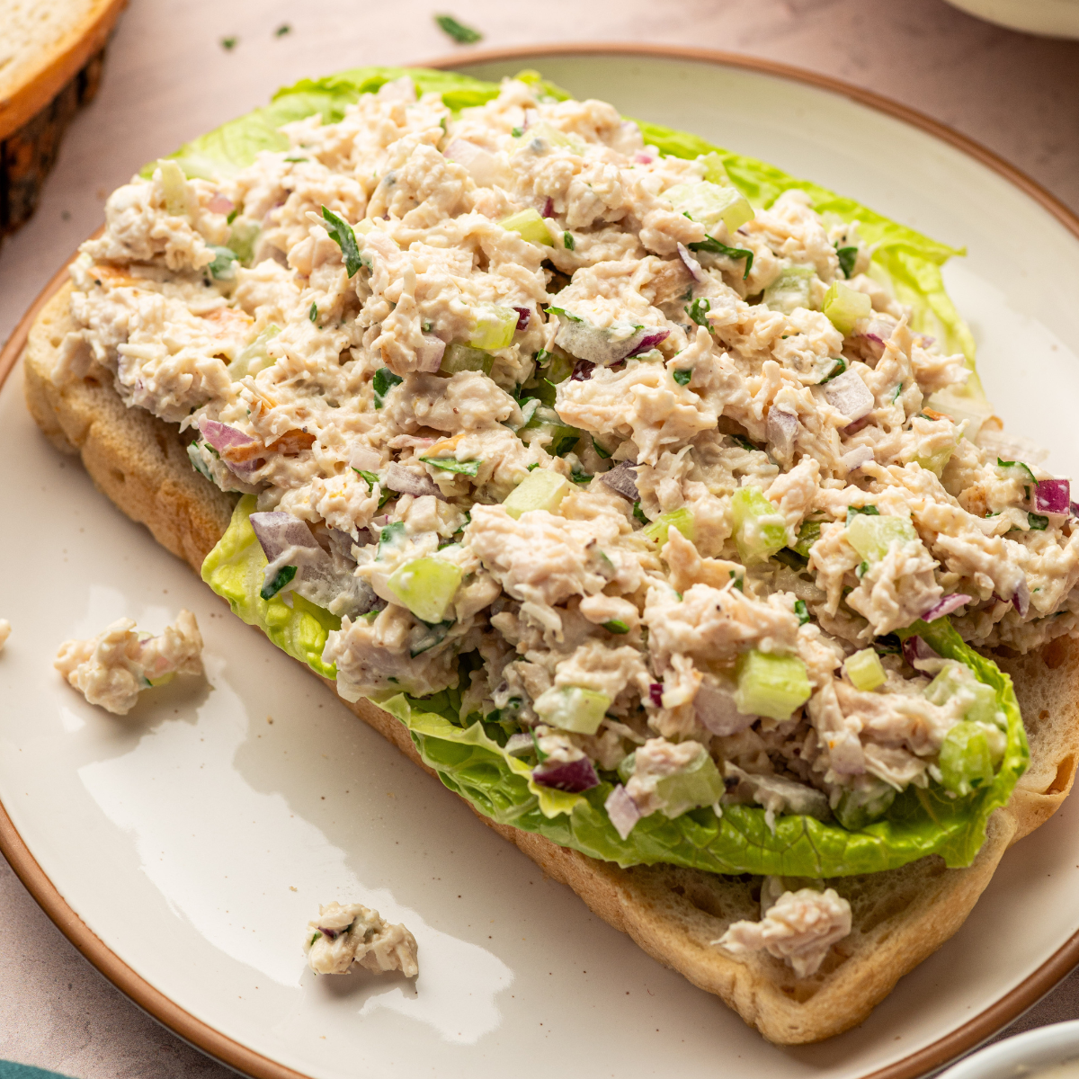 Healthy Caesar Chicken salad over lettuce and toast.