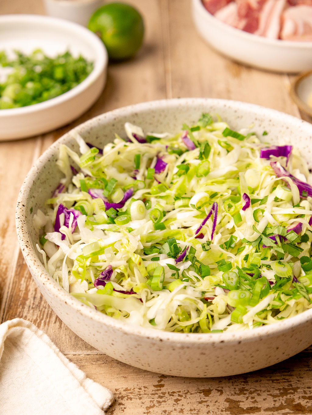 Cabbage slaw in a white mixing bowl.