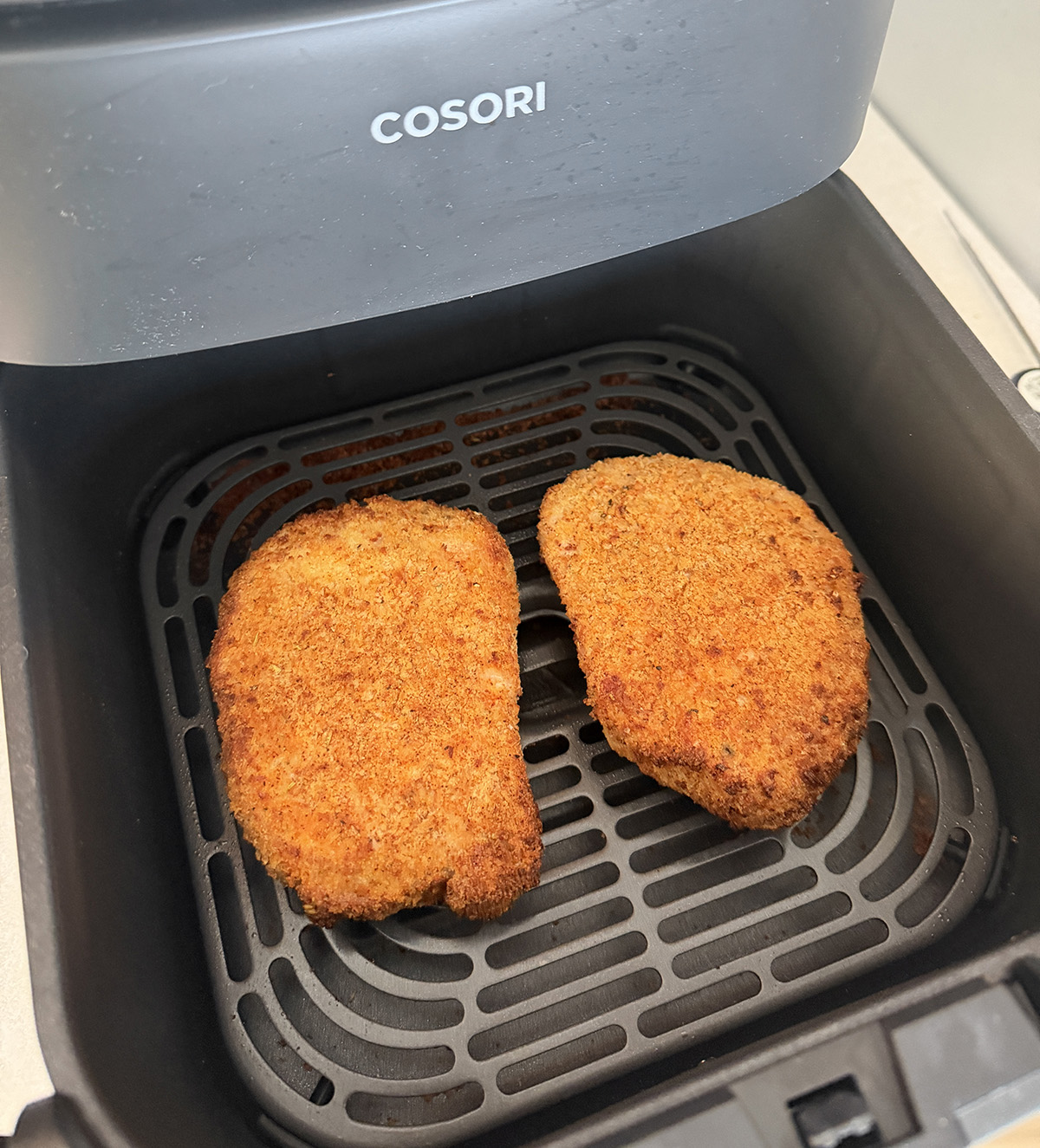 Two golden crunchy breaded pork chops made in the air fryer.