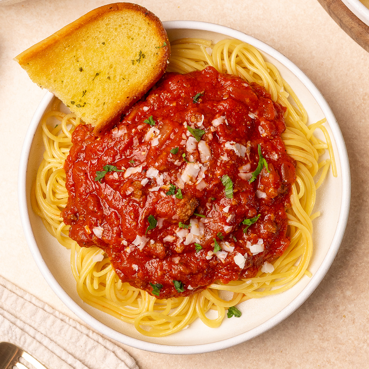 A plate of spaghetti with meat sauce and garlic bread.
