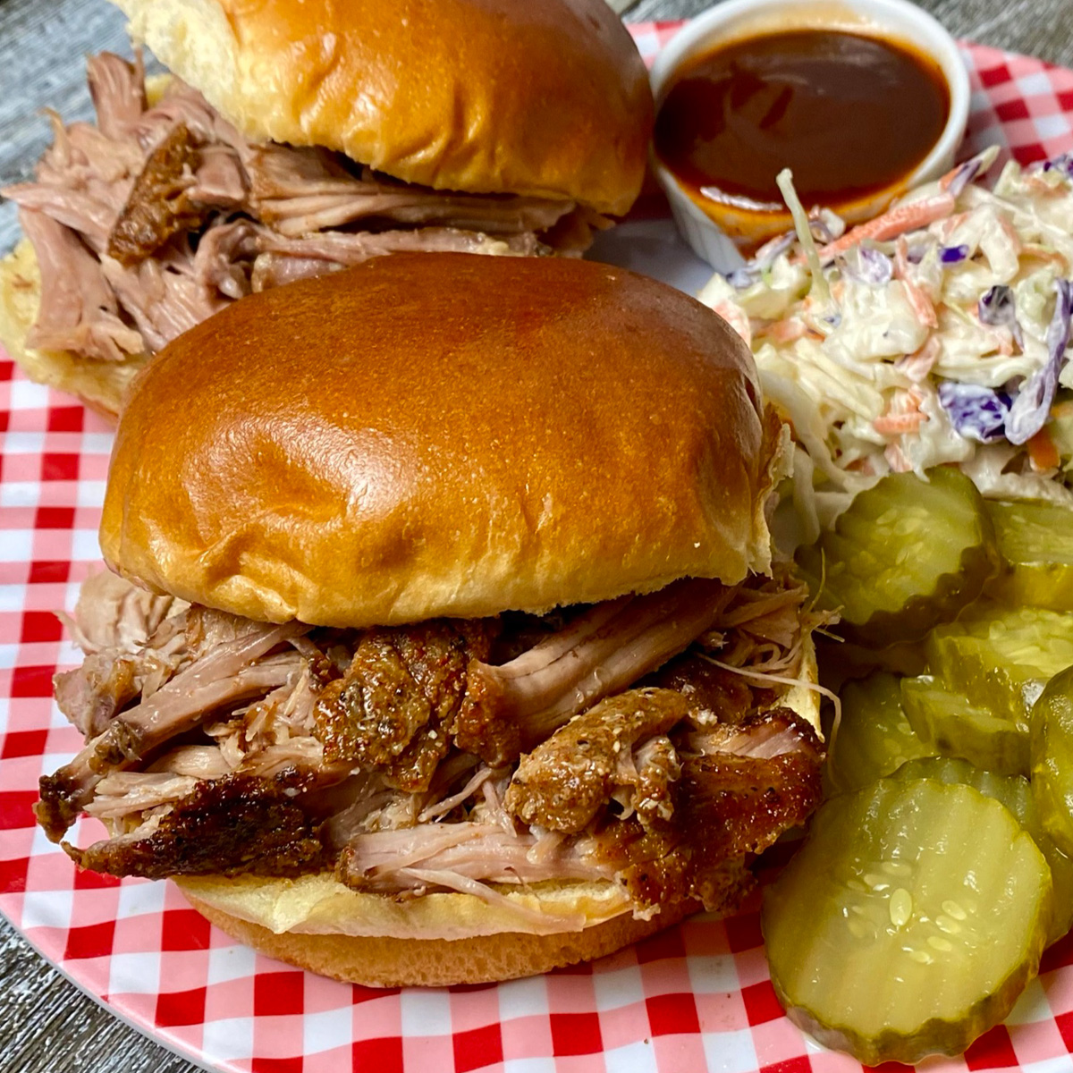 Pulled pork made in a slow cooker served on buns with BBQ sauce and cole slaw.